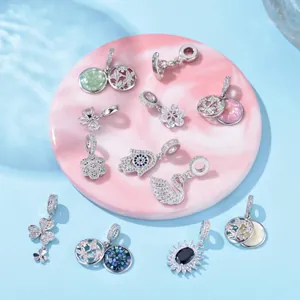 Detailed collection of zircon insect and floral charms on a marble tray background