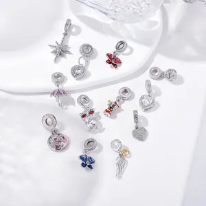 Detailed macro of S925 silver charms set with cubic zirconia and enamel icons