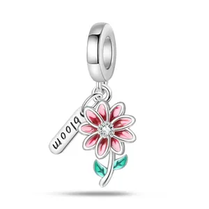 Silver flower charm pendant with pink enamel petals and engraved bloom tag on ring