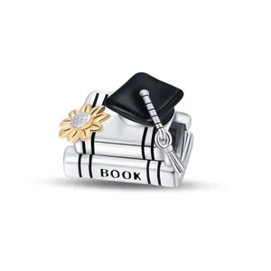Macro detail of graduation charm featuring black academic cap and yellow sunflower on books