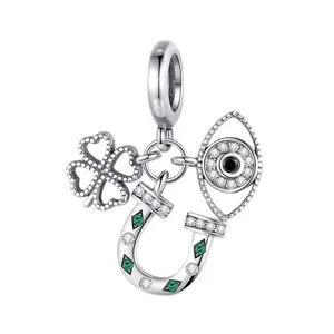 Detailansicht von Kleeblatt, Hufeisen und Auge-Amulett aus Silber mit grünen Zirkonia-Steinen