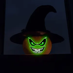 Dettaglio zucca di Halloween con cappello da strega nero e viso neon verde brillante