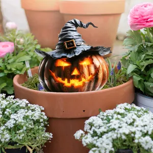 Close-up of a glowing Halloween pumpkin with a wizard hat placed in a floral garden setting