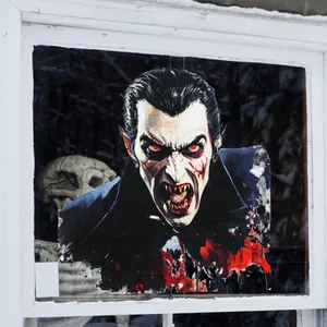 Détail d'un autocollant de vampire effrayant pour fenêtre avec crâne d'Halloween et fond de neige