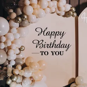 Detail of elegant cream and gold balloon arch with Happy Birthday arched backdrop