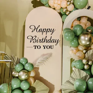 Detail of bohemian Happy Birthday party set with sage green balloons and arch backdrop