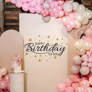 Detail of beige Happy Birthday backdrop with gold stars and elegant black lettering