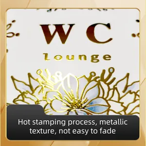 Λεπτομέρεια macro λευκής πινακίδας WC Lounge με χρυσή θερμοτυπία και φλοράλ σχέδιο