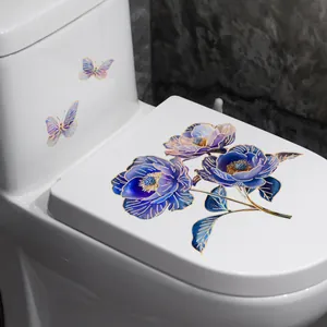 Detail of blue and purple floral toilet stickers with gold trim on a white surface