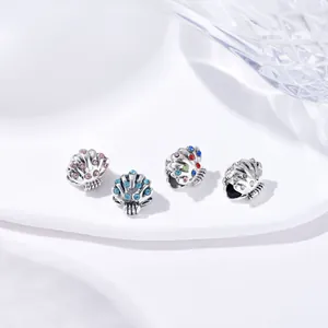 Detail van zilveren schelpbedeltjes met gekleurde strass-steentjes voor DIY-sieraden