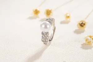 Détail d'une bague en argent avec perle ronde et pavage de zircons style dentelle