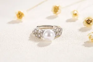 Gros plan d'une bague réglable en dentelle avec perle centrale et pavé de diamants