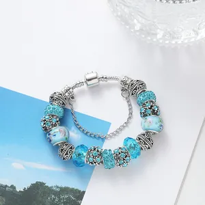 Sky blue DIY charm bracelet with glass bubble beads and rhinestones on a white background