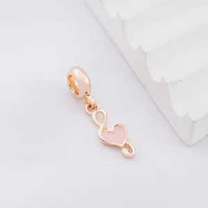 Detailed macro view of rose gold musical note charm with pink enamel heart detail