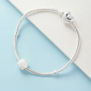 Zilveren slangenarmband met hartsluiting en kraal met oceaangolven patroon