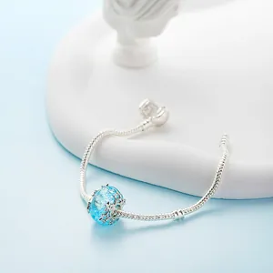 Eisblauer Schneeflocken-Charm auf silbernem Schlangenarmband mit gefrosteter Kristalloptik