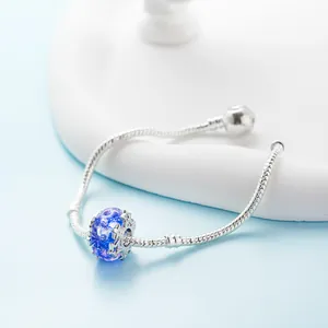 Silbernes Schlangenarmband mit tiefblauer Sternenglasperle auf weißem Displayständer