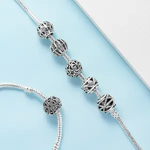 Retro hollow silver charm beads on a classic snake chain bracelet with floral engraving