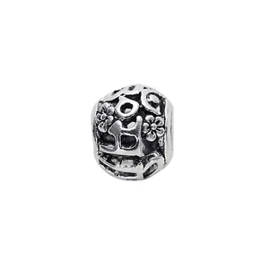 Macro shot of vintage silver hollow charm bead with intricate floral and geometric patterns