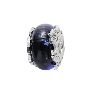 Makroansicht blauer Glasanhänger mit silbernen Schneeflocken und Glitzer für Armbänder