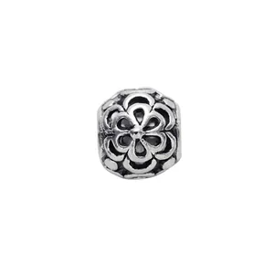 Macro view of retro silver floral charm bead with intricate hollow flower patterns