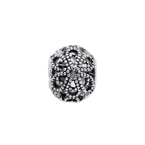 Macro shot of retro openwork silver bead with intricate bohemian floral pattern