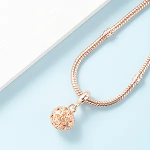 Bracelet maille serpent en or rose avec un pendentif sphérique ajouré en forme de cœur