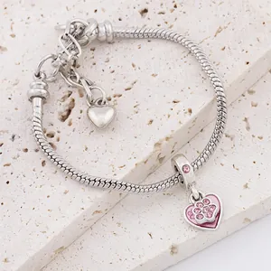 Silver snake chain bracelet featuring pink heart paw charm and smooth heart pendant