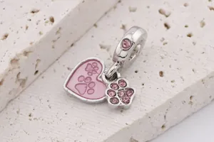 Macro shot of silver charm with pink enamel heart and crystals for jewelry making