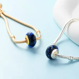 Faceted navy blue glass charms with fine shimmer on silver and gold snake chain bracelets