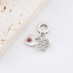 Silver heart pendant with red gemstone and infinity symbol on marble background