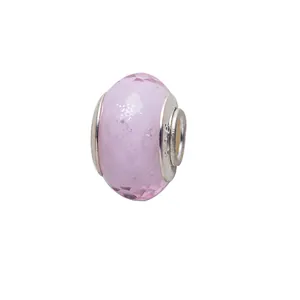 Macro detail of faceted pink glass charm bead with polished silver metal edges