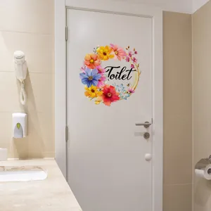 Blumenkranz Wandtattoo mit Toilet-Schriftzug auf einer weißen Badezimmertür Oberfläche