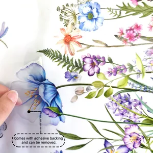Close-up of hand peeling a colorful floral transparent wall sticker with adhesive backing
