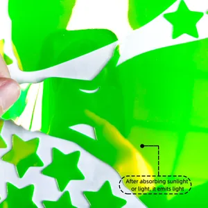Macro shot showing hand peeling luminous star stickers from self-adhesive backing