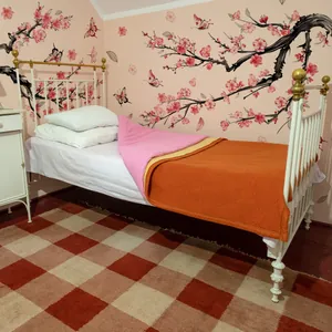 White vintage iron single bed frame with gold decorative accents and pink bedding decor