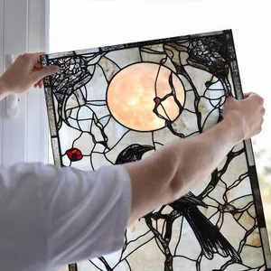 Artistic window film featuring black birds and orange moon on textured glass pane