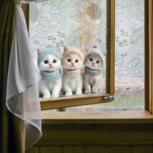 Drei Kätzchen mit bunten Strickmützen und Schals auf einer rustikalen Holzfensterbank