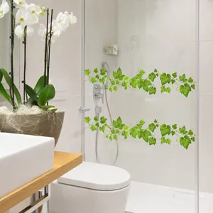 Detail of green vine wall stickers applied on glass door in a modern minimalist bathroom