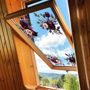 Detail of vintage purple rose window decals on a wooden attic window against blue sky