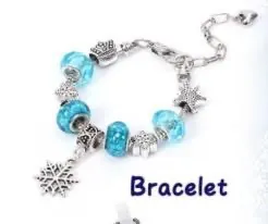 Dettaglio del bracciale natalizio con perline di vetro blu e ciondoli a fiocco di neve