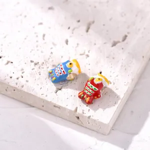 Close-up of blue and red koi fish ceramic alloy charms with detailed enamel dripping