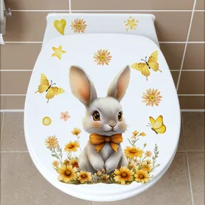 Gros plan d'un autocollant lapin de Pâques et fleurs sur un couvercle de toilette blanc