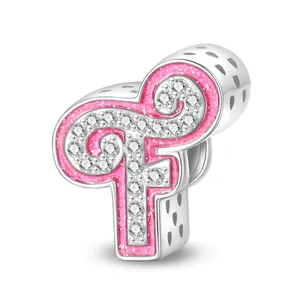 Macro detail of pink glitter letter charm with clear zircons and heart cutouts