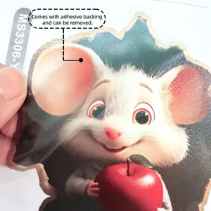 Detail showing hand holding a 3D cartoon mouse wall sticker with a red apple and gloss finish