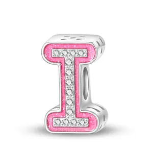 Macro shot of pink enamel alphabet I charm with zircon stones for DIY bracelets