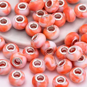 Macro detail of orange marble resin beads with metal core for DIY jewelry making