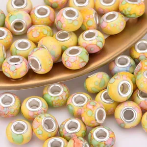 Macro shot of 14mm yellow resin beads with colorful watercolor pattern and metal core