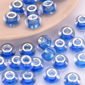 Detalle macro de cuentas de vidrio azul translúcido con núcleos de plata para hacer joyería