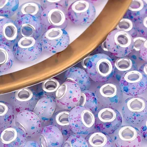 Macro view of purple resin large hole beads with artistic colorful ink splatter patterns